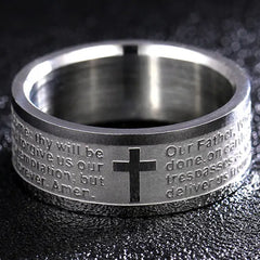 A silver-toned stainless steel ring engraved with the Lord's Prayer and a central cross.