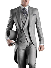 A man wears a slim-fit grey three-piece tuxedo with a peaked lapel and a top hat.