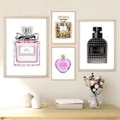 A set of four framed perfume bottle art prints displayed on a wall above a wooden console table.