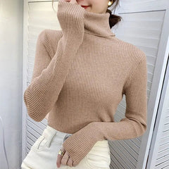 A woman wears a beige, slim-fit, ribbed turtleneck sweater with long sleeves.