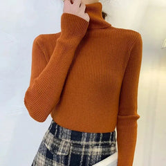 A woman wears a slim-fit, long-sleeved, rust-orange ribbed turtleneck sweater.