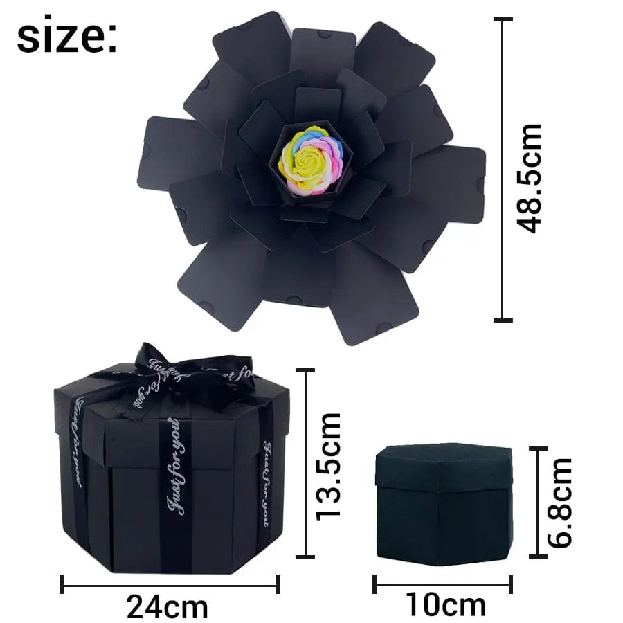 The Hexagon Explosion Box Scrapbook Album is a black hexagonal gift box with a ribbon, opening to reveal petal-like layers and a colorful artificial rose—ideal for DIY scrapbooks or surprise gifts. Size: 24x13.5x10 cm (closed), 48.5 cm (open).