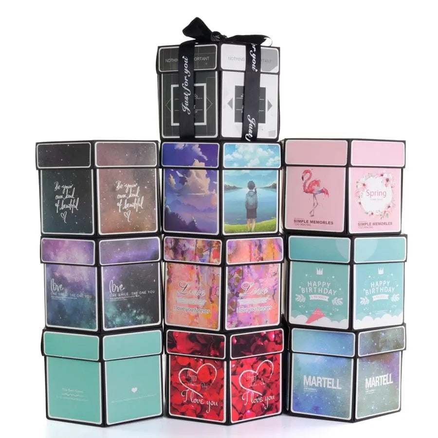 A stack of colorful gift boxes features cheerful messages like “Happy Birthday,” topped with two tied in black ribbon, bringing to mind the creativity of a DIY Hexagon Explosion Box Scrapbook Album.
