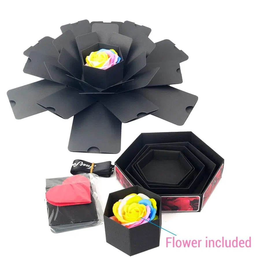 The Hexagon Explosion Box Scrapbook Album is a black, flower-shaped gift box with layered petals that open to reveal a rainbow artificial rose, heart-shaped notes, ribbon, and octagonal boxes—ideal for DIY handmade scrapbooks or photo albums.