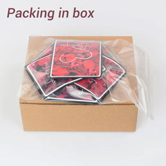 The Hexagon Explosion Box Scrapbook Album comes in a brown cardboard box with square cards featuring red floral designs, ideal for DIY scrapbooks or photo album gifts. "Packing in box" is shown above, with cards partially inside a clear plastic bag.
