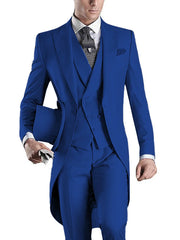 A man wears a slim-fit royal blue three-piece tuxedo with a long tailcoat and a patterned tie.