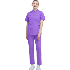 A woman wears a purple short-sleeved medical scrub top and matching trousers.