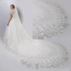 A long, single-layer cathedral wedding veil featuring a wide, sequined lace edge.