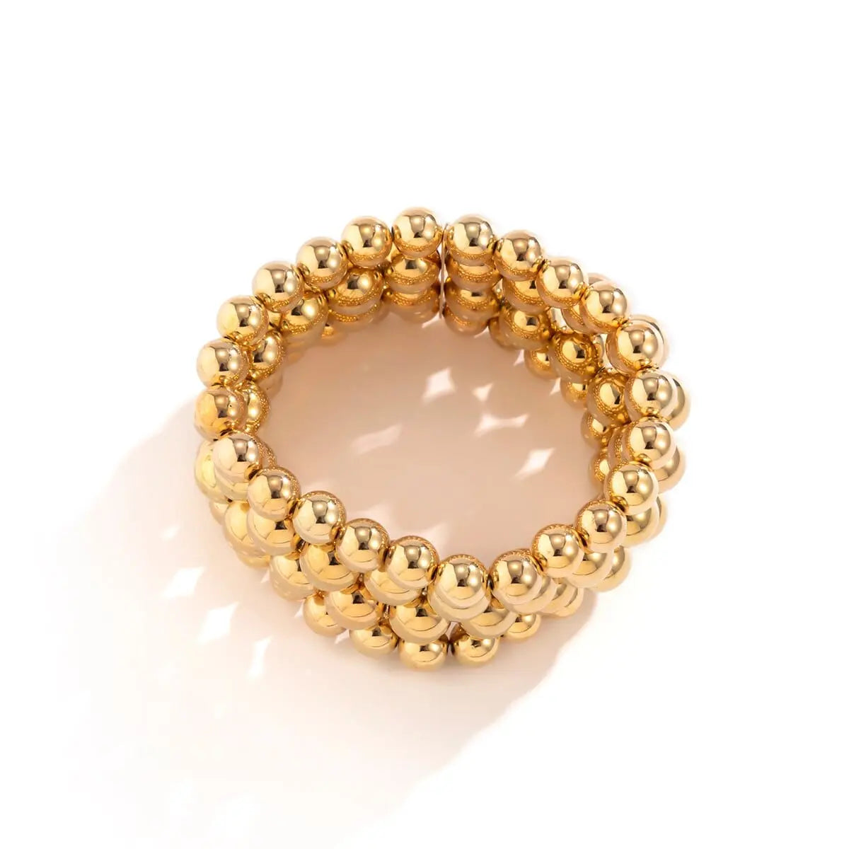 A multi-layered gold-tone chunky ball necklace made of plastic beads.