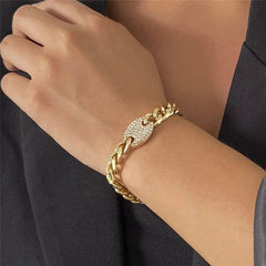 A person wearing a gold chain bracelet with a diamond-encrusted oval centerpiece pairs it with the Ingemark Iced Out Rhinestones Tennis Chain Pendant Choker Necklace, shown on their wrist against a dark, long-sleeved top.