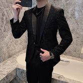 A man wears a slim-fit black blazer featuring vertical stripes and a subtle sequined finish.