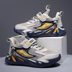 A pair of grey and navy blue children's sneakers with yellow accents and hook-and-loop straps.