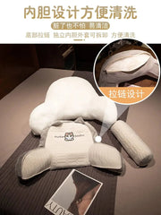 A plush bedside backrest cushion with a removable cover and a separate inner liner.