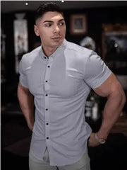 A man wears a light gray short-sleeved slim-fit button-down shirt.