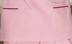 A light pink nurse scrub top featuring two front pockets with dark red trim.