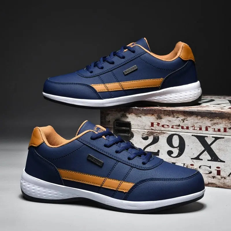 Men's Sneakers 2022: Stylish navy blue mesh shoes with orange accents and white soles, one lace-up sneaker laid flat and the other propped on a vintage-style box. Lightweight, anti-skid, breathable men's fashion sports shoes.