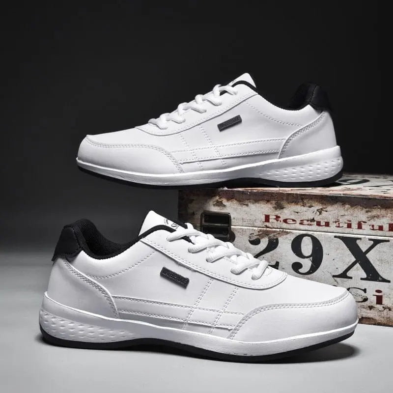 Men's Sneakers 2022 New Lightweight Vulcanized Shoes, featuring anti-skid soles and black accents, are displayed side by side on a vintage wooden box. The scene has a dark, minimalist background that highlights these trendy casual sports shoes.