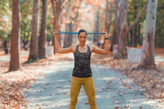 A woman wears a navy tank top featuring a gold star pattern while exercising outdoors.
