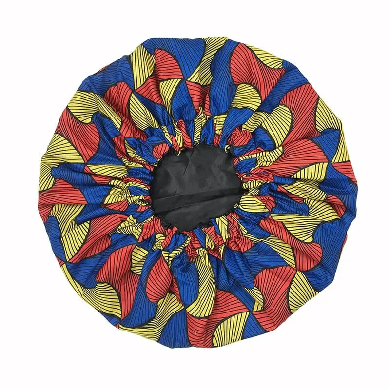 The New African Ankara Pattern Satin Lined Bonnet is a vibrant, double-layer headwrap with red, yellow, and blue wavy stripes. This big-size, multifunctional cap protects hair in style with its colorful gathered elastic design and long ribbon.