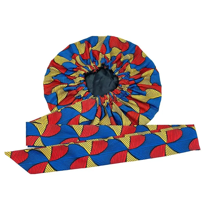 The New African Ankara Pattern Satin Lined Bonnet features a vibrant geometric print in red, yellow, and blue on black. This big-size adult hair cover includes a long ribbon headwrap and double-layer design for versatile style and protection.