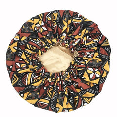 The New African Ankara Pattern Satin Lined Bonnet features a beige center and a vibrant yellow, black, and brown geometric floral outer layer, making it a stylish headscarf or multifunctional skull cap for women.