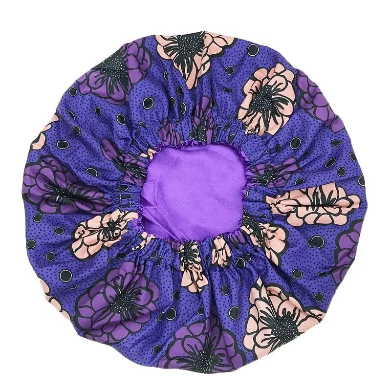 The New African Ankara Pattern Satin Linned Bonnet is a big size, double-layer headscarf for women, featuring a purple and floral design with an elastic edge and long ribbon, perfect as a stylish hair cover or multifunction skull cap.
