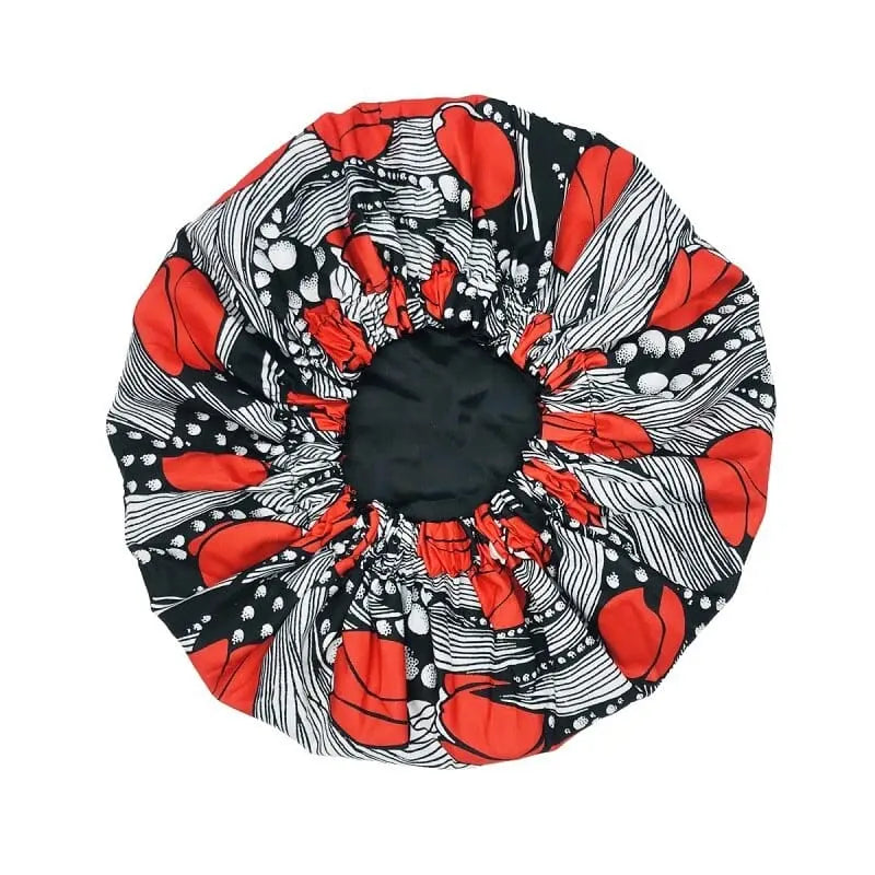 The New African Ankara Pattern Satin Lined Bonnet features a bold red, white, and black abstract design with an elastic edge and long ribbon, perfect as a multifunctional skull cap or women’s beanie headscarf.