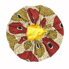 The New African Ankara Pattern Satin Lined Bonnet features a vibrant red, yellow, black, and beige design with an elastic bright yellow satin opening—ideal as a women’s beanie, multifunction skull cap, or long ribbon headwrap.