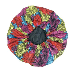 The New African Ankara Pattern Satin Lined Bonnet is a colorful women's headwrap featuring a bold floral print in red, yellow, blue, and black with a black center, plus long ribbons and double-layer satin for adult hair coverage.