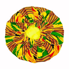 The New African Ankara Pattern Satin Lined Bonnet features a vibrant kente-inspired yellow, green, red, and black design, a gathered center with stretchy band, and a long ribbon headwrap for adult hair coverage.