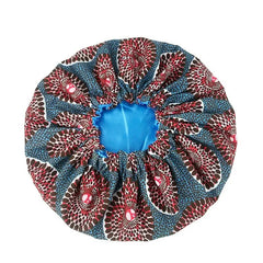The New African Ankara Pattern Satin Lined Bonnet is a big-sized women's headwrap featuring a red, black, and white geometric outer with blue accents, blue inner lining, elastic band, and long ribbon for chic and comfortable hair coverage.