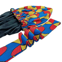 The New African Ankara Pattern Satin Lined Bonnet is a big size, double-layer headscarf for women. It features vibrant red, blue, and yellow patterns with black lining and long ruffled ribbons for a comfortable, stylish fit.