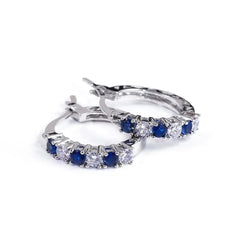 A pair of sterling silver hoop earrings featuring alternating blue and clear round zircon stones.