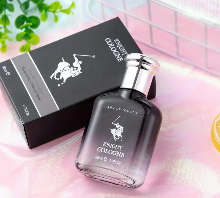 A bottle of New Black Knight perfume Eau De Toilette for men stands before its black box on a pink surface. The sleek dark bottle with silver cap showcases expert cosmetics R&D design.