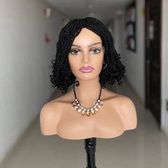 A mannequin head wears a short, black, kinky twist crochet braided wig with curly ends.