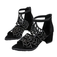 Black faux leather sandals with rhinestone embellishments, a cutout design, and a thick heel.