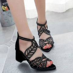 Black faux leather sandals with rhinestone embellishments, a cutout design, and a thick block heel.