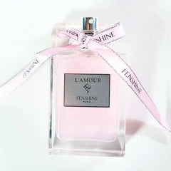 A rectangular glass perfume bottle filled with pink liquid and tied with a branded pink ribbon.