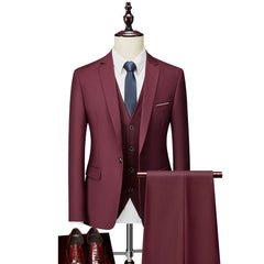 A slim-fit burgundy three-piece suit with a single-breasted jacket, vest, and matching trousers.