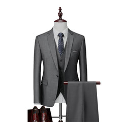 A grey slim-fit three-piece suit with a white shirt, patterned tie, and brown dress shoes.