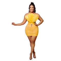 A woman wears a yellow sleeveless mini dress featuring a feathered tube top and a ruched skirt.