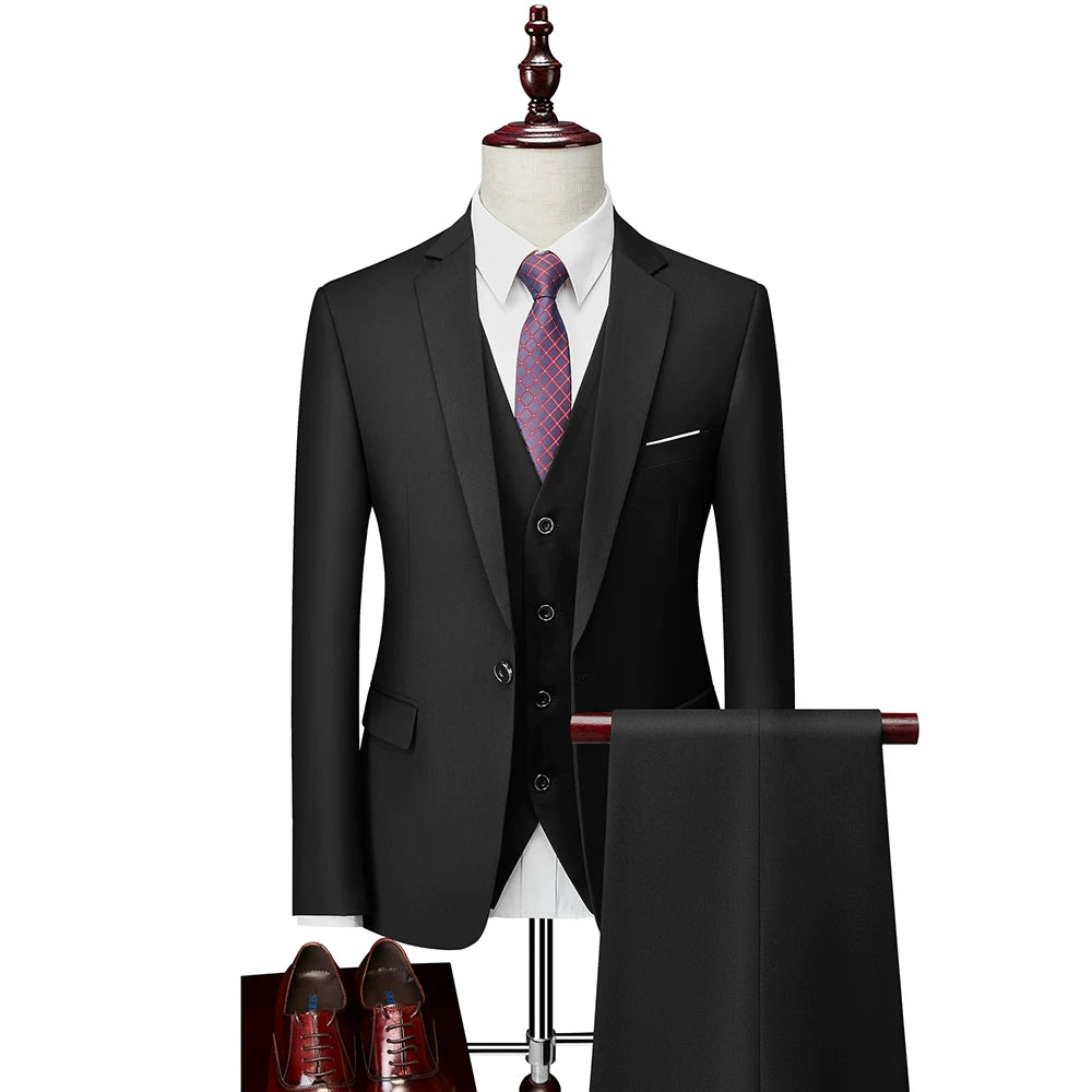 A black slim-fit three-piece suit with a white shirt, patterned tie, and matching trousers.