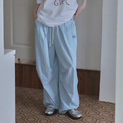A person wears light blue, loose-fitting, quick-dry pants with a drawstring waist and side pockets.