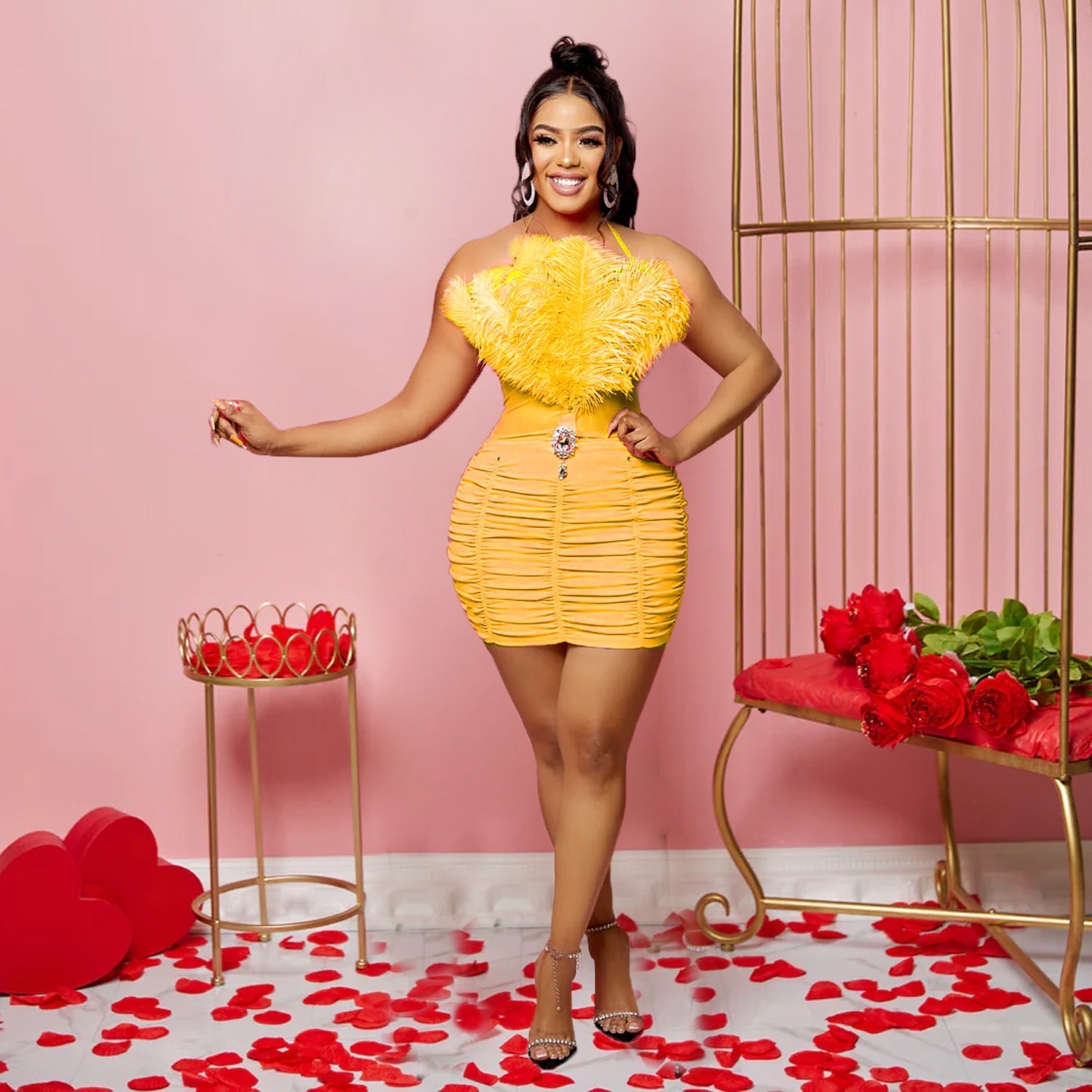 A woman wears a yellow sleeveless tube top mini dress featuring a feathered bodice and ruching.
