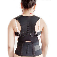 A person wearing a black posture corrector brace with adjustable straps and back support.