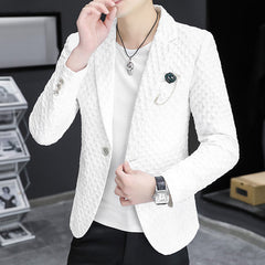 A man wears a white slim-fit casual blazer with a textured fabric and a lapel pin.