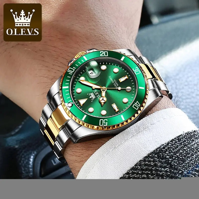 A close-up of a wrist wearing the OLEVS Mens Quartz Watch, featuring a green dial and silver-gold stainless steel band. This top brand luxury business watch adds sophisticated style to a suit, perfect for professionals on the go.