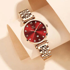 A gold-tone OLEVS women's quartz watch with a red dial, diamond markers, and a metal link strap.