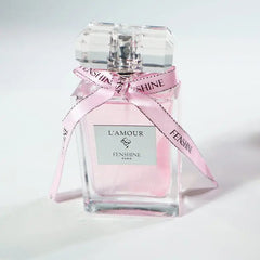 A rectangular glass perfume bottle filled with pink liquid and tied with a branded pink ribbon.