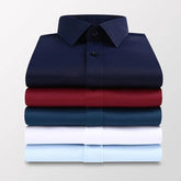 A stack of five long-sleeved men's dress shirts in navy, red, dark blue, white, and light blue.